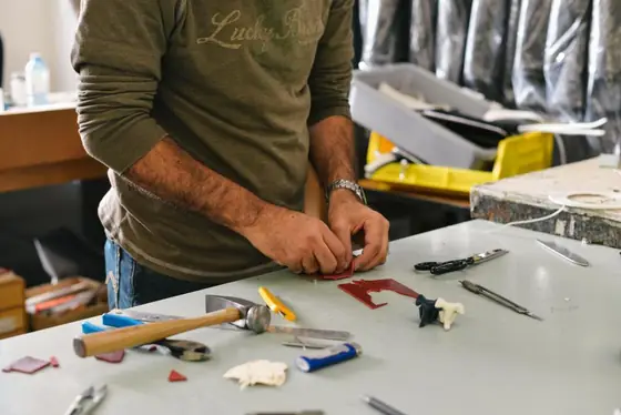 Technician working at a bench covered in hand tools