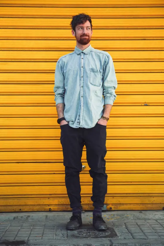 Andre standing in front of a yellow wall