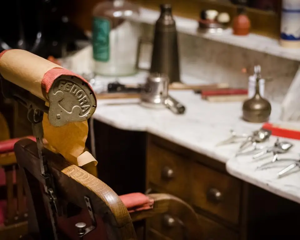 Vintage barber chair and mirrored station with clippers and combs laid out