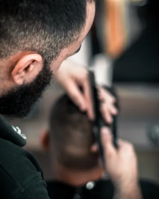 Barber trimming a client's hair with clippers