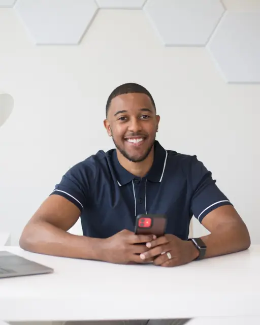 Andre, owner of Fresh Tread, smiling at a desk