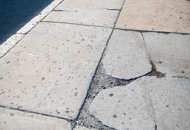 Cracked concrete sidewalk slabs before repair