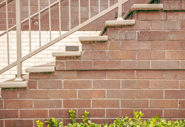 Brick steps and masonry wall with a railing