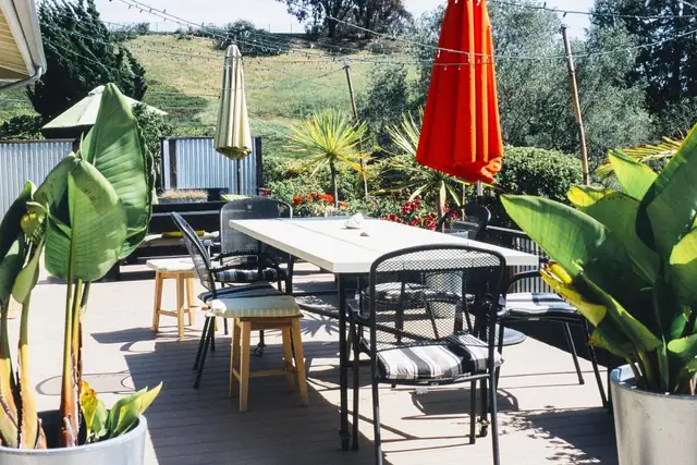 Deck with a dining table, umbrella and plants
