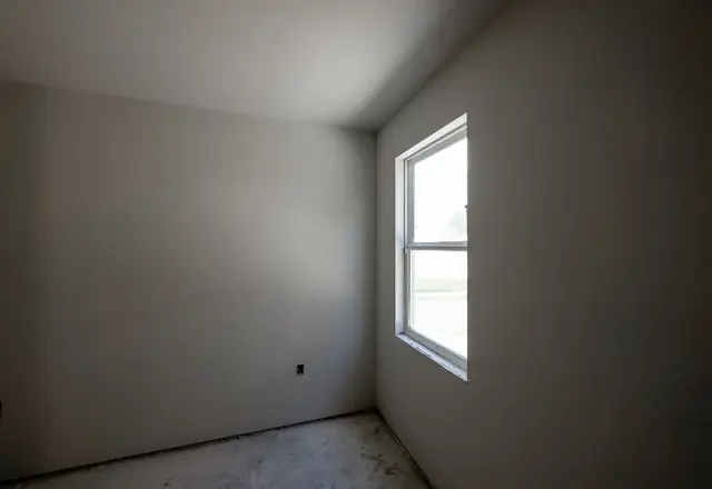 Empty room with smooth gray walls and a window