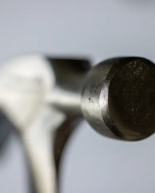 Close-up of a hammer against a light wall