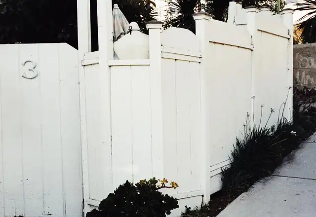 White vinyl privacy fence along a sidewalk