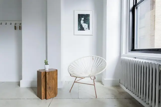 White room with light tile floor and a radiator