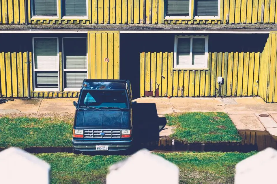 Yellow clapboard house with a pickup truck in the driveway