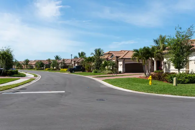 Suburban street with houses and green lawns
