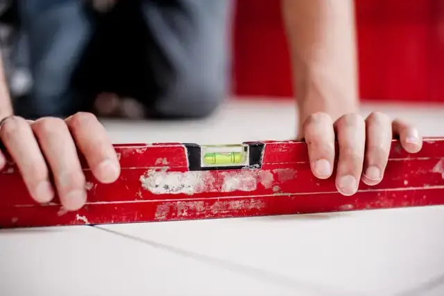 Leveling a shelf with a red spirit level