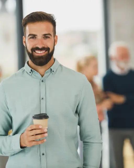 Ryan, owner of Bluestem Heating & Air, holding a coffee
