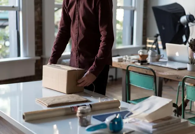 Person packing cardboard boxes in an apartment