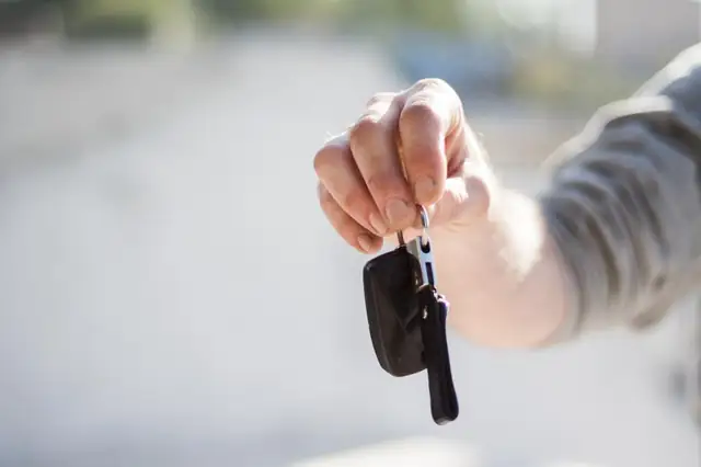 Hand holding a new car key and fob
