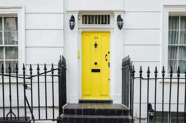 Bright yellow front door with brass hardware