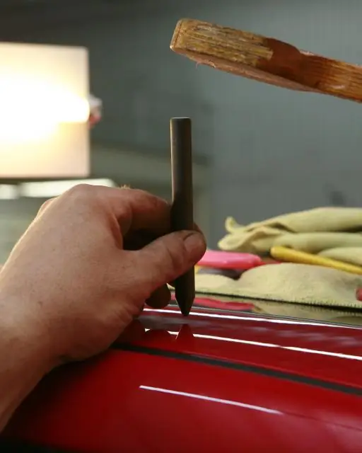 Mechanic's hand working on a red car