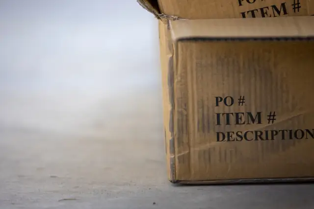 Stacked cardboard moving box labeled item and description