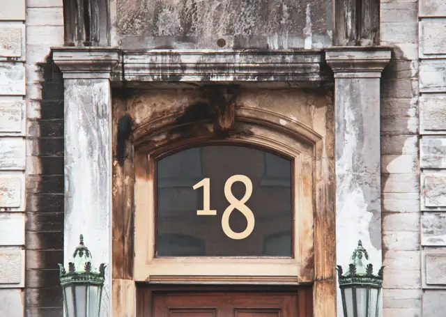 Brass house number beside a front door