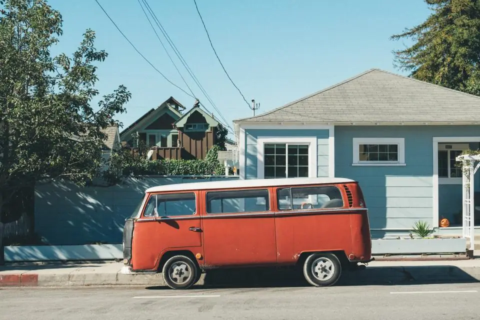 Orange van parked in front of a blue house