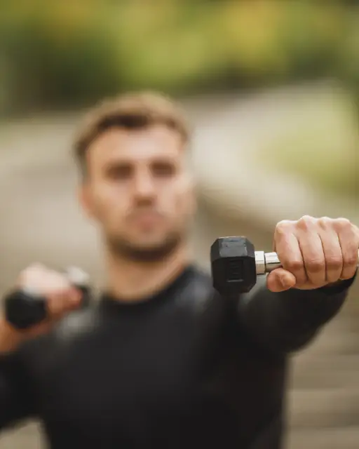 Coach holding a pair of dumbbells