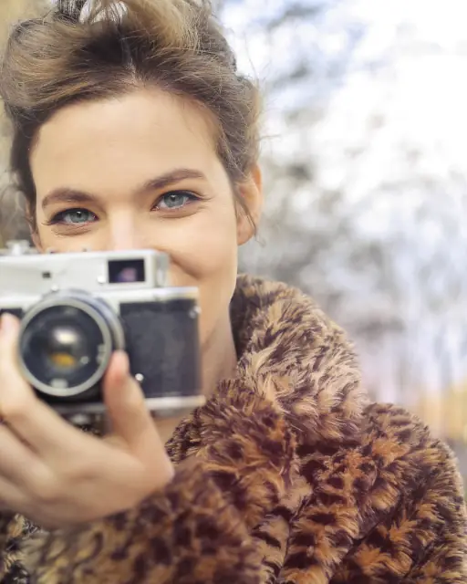 Photographer smiling behind a vintage camera