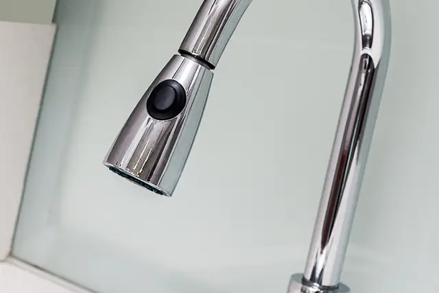 Chrome pull-down kitchen faucet over a stainless sink