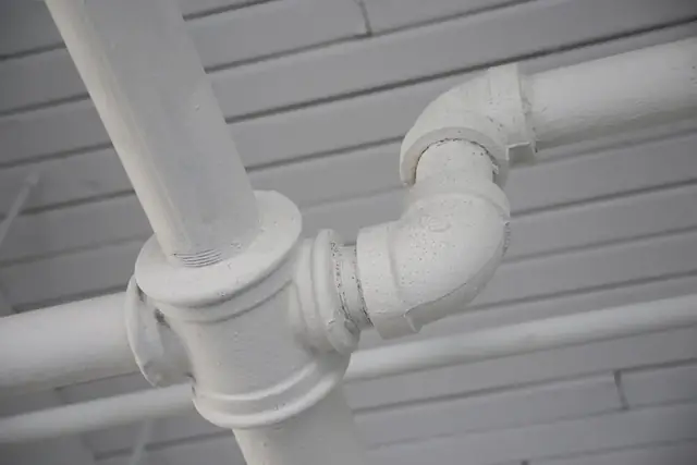 White painted pipes along a ceiling