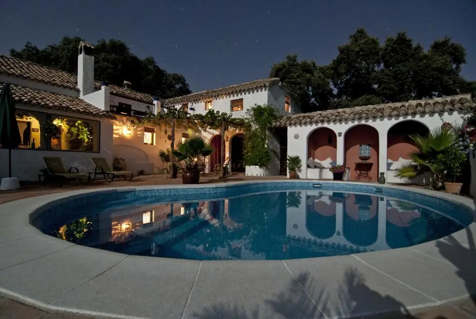 Backyard swimming pool lit up at dusk