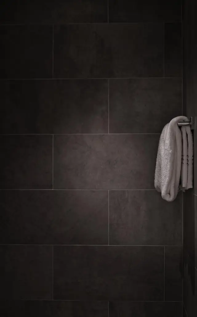 Dark tile bathroom wall with a towel hook