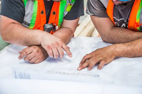 Hands reviewing renovation plans on a table