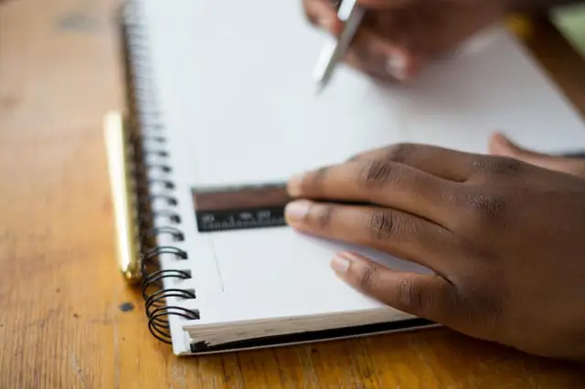 Student writing notes in a notebook