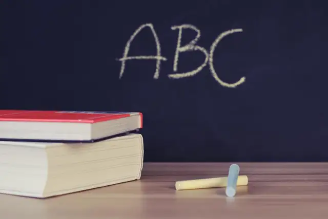 Chalkboard with ABC written beside a stack of books