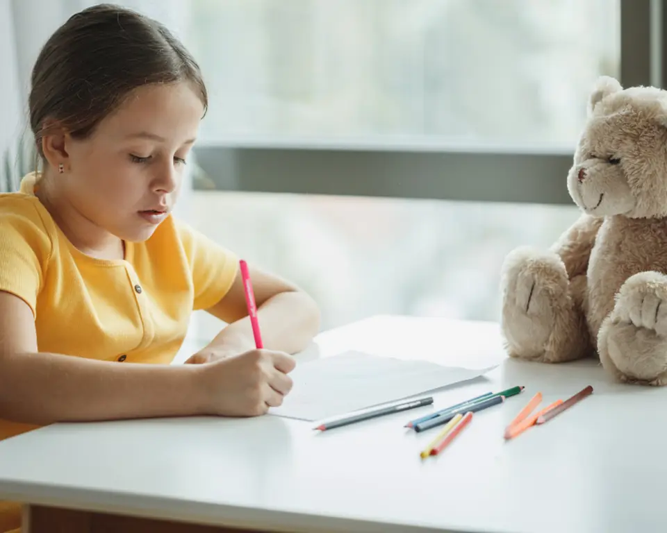 Young student doing homework at a bright desk