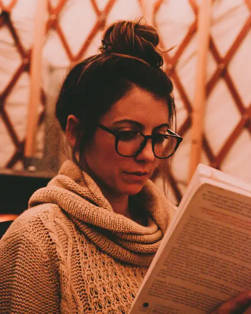 Tutor with glasses reading a book