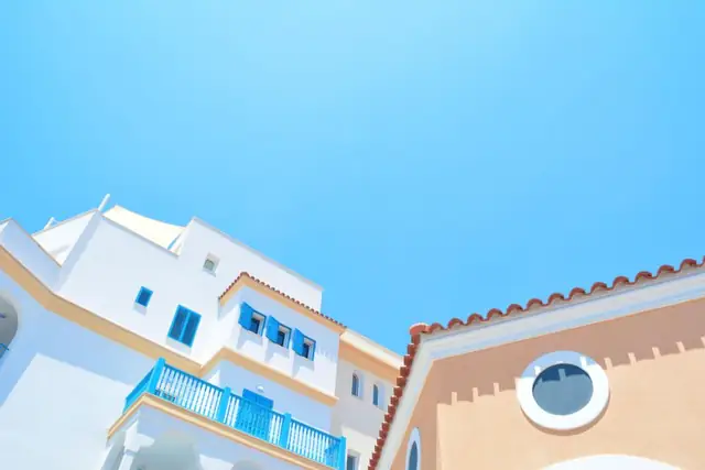 Pastel houses with balconies under a blue sky