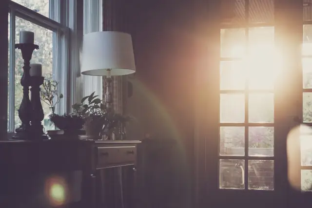Sunlit room with tall windows at dusk